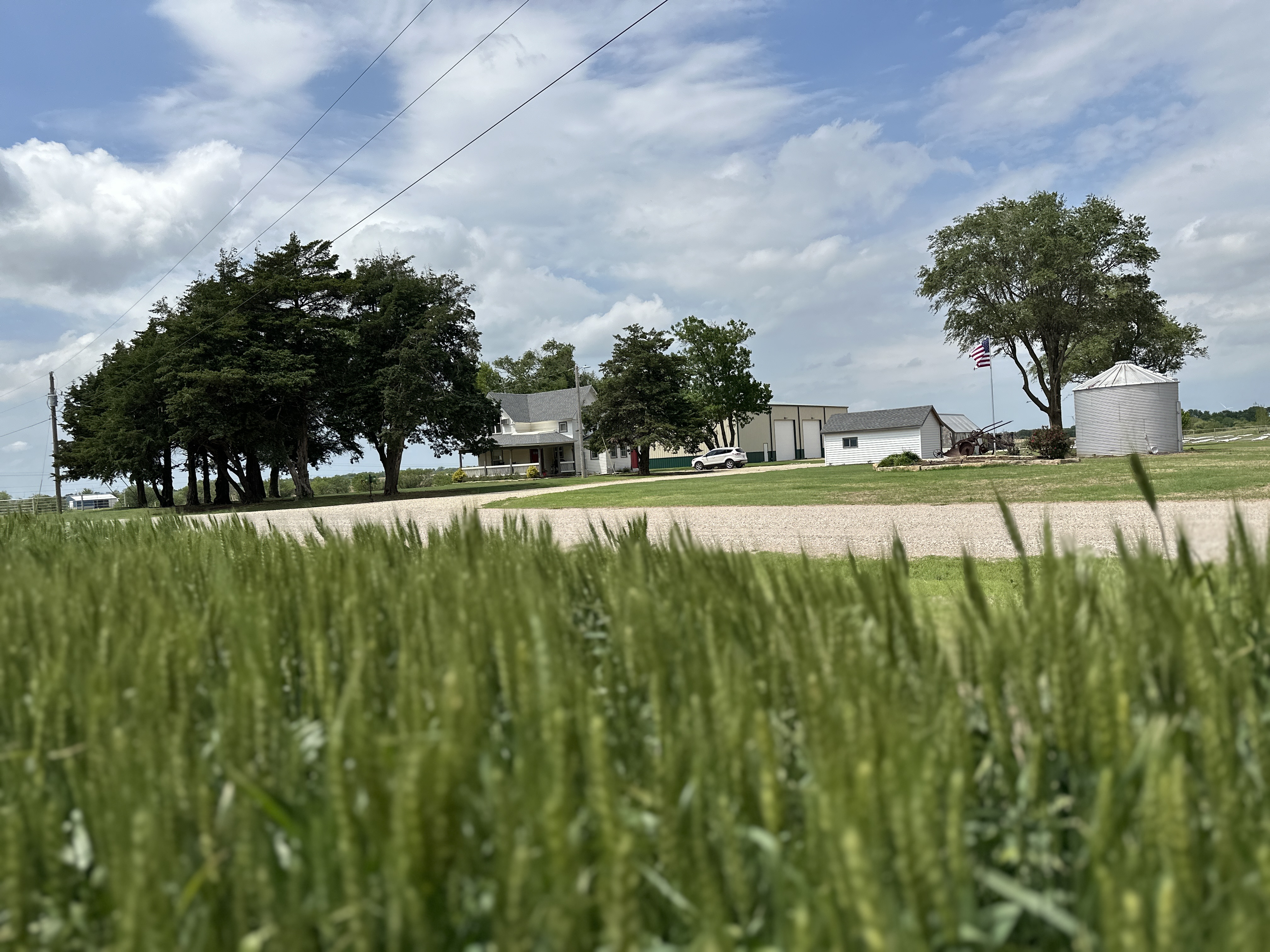 a farm with a silo sits against a blue sky